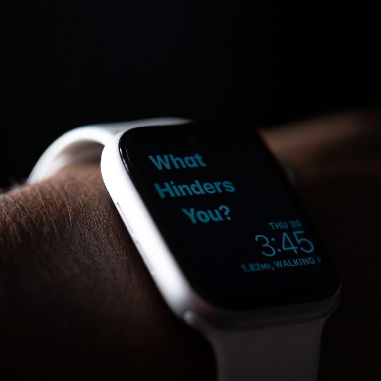 A sleek smartwatch on a wrist showcases the message "What Hinders You?" while also displaying the time, 3:45, and walking distance, 1.82 miles.