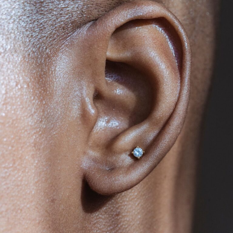 Close-up of an ear with a small diamond stud earring.