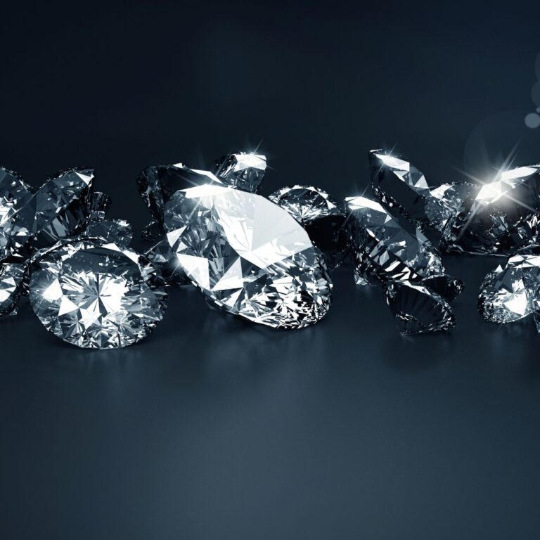 A collection of April birthstone gifts, featuring sparkling cut diamonds of various shapes, rests elegantly on a dark surface.