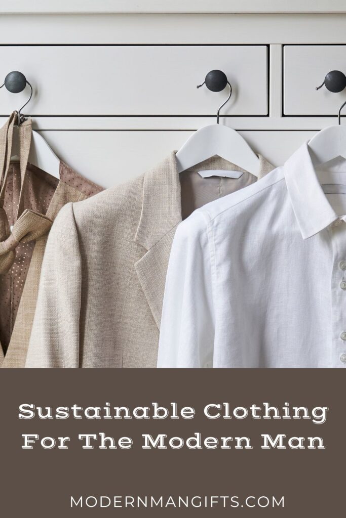 Neutral-toned blazers and shirts hang on hooks and hangers, embodying sustainable clothing for the modern man. Overlay text reads: "Sustainable Clothing For The Modern Man" with website "modernmangifts.com" at the bottom.